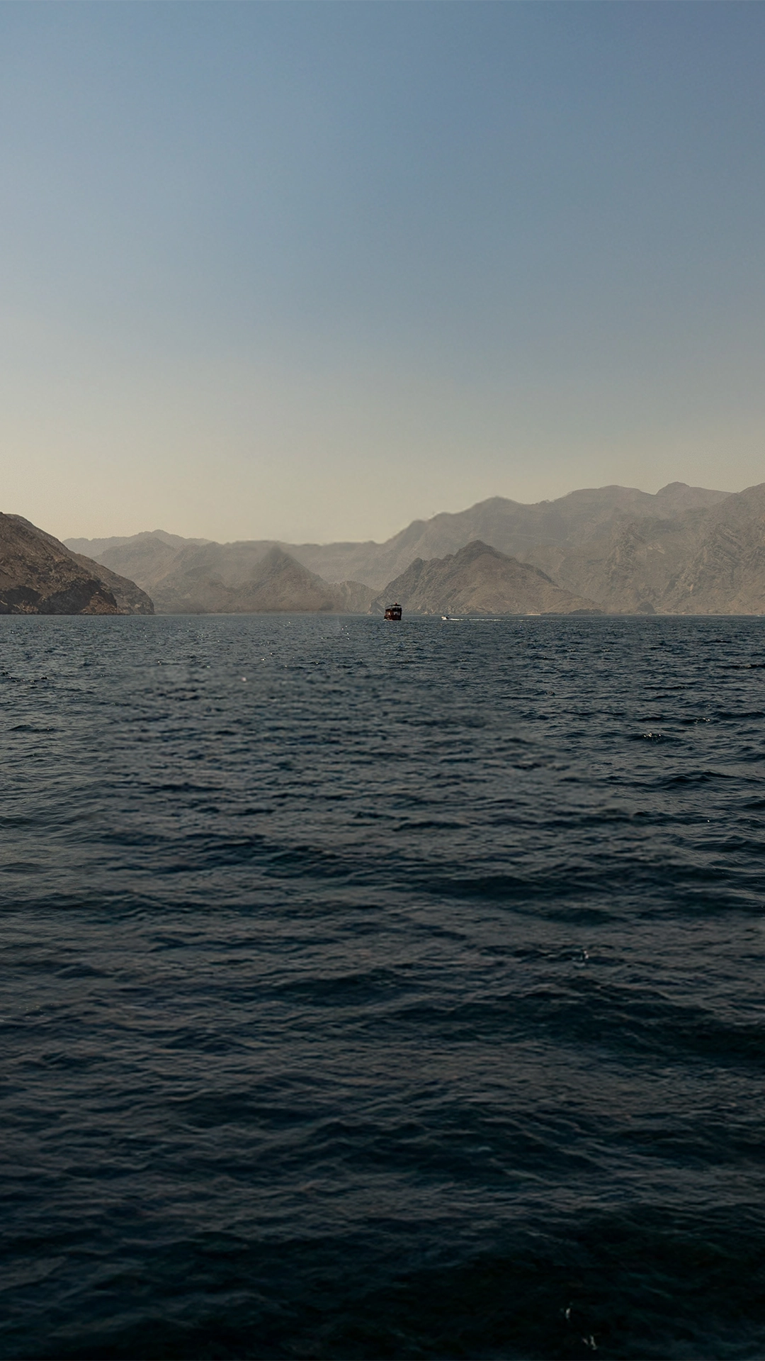 A dramatic shot of a of seascape and mountains in the distance.