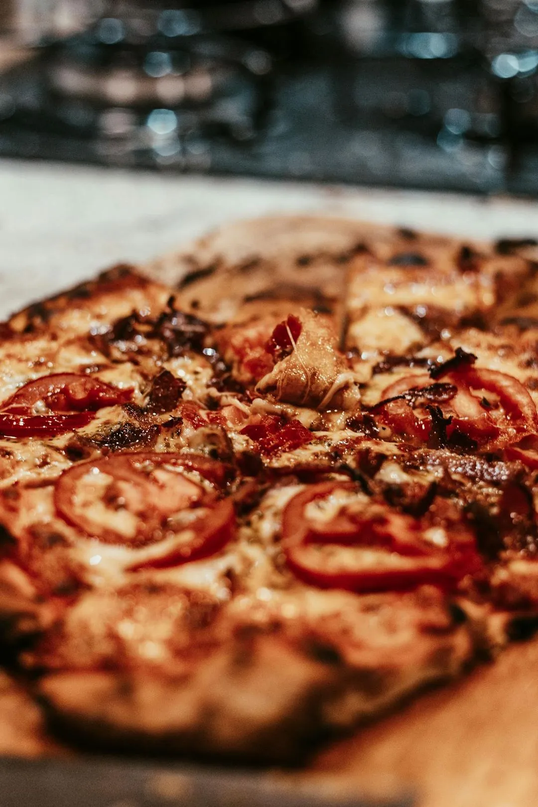 A close up of a pizza with tomatoes and cheese.