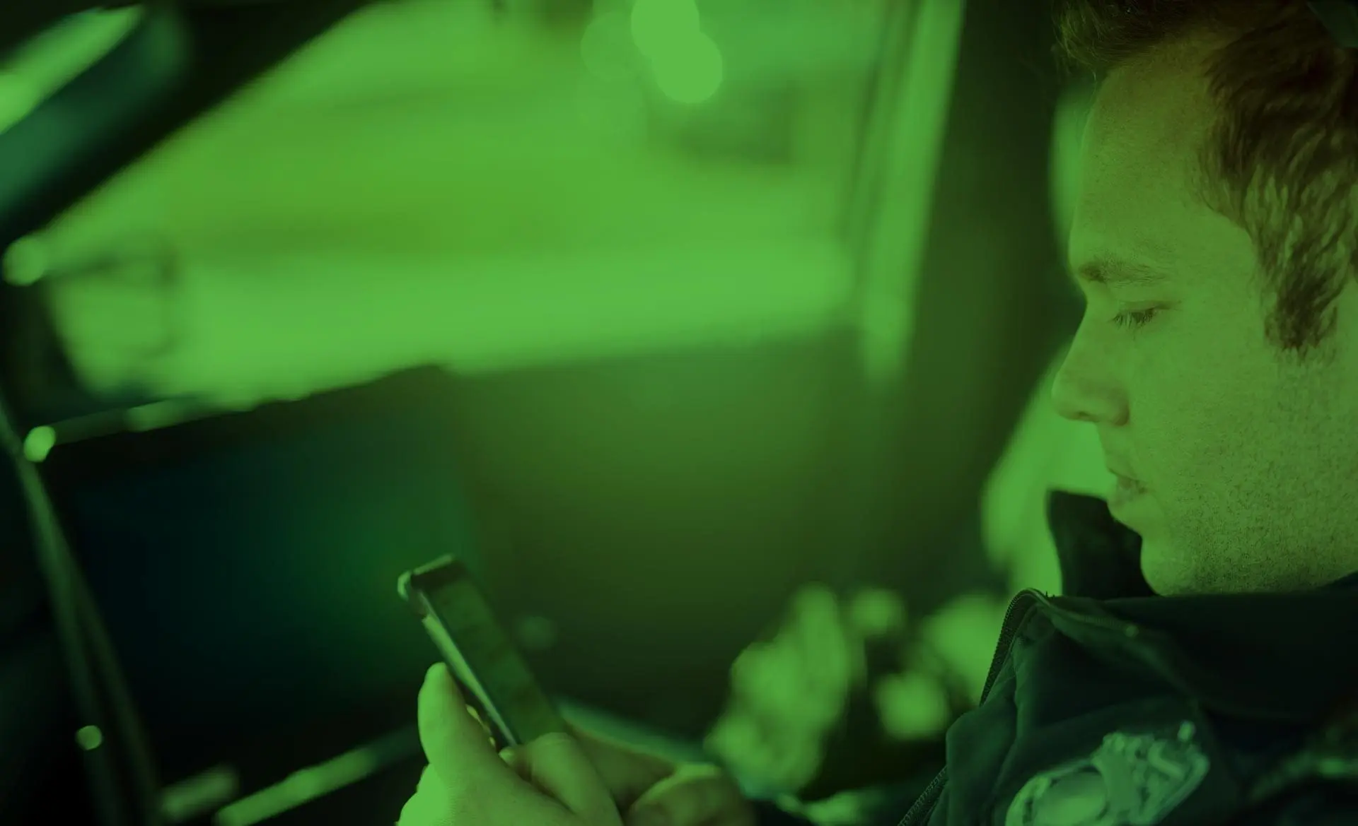 Police officer using Tango Tango messaging on a smartphone in a patrol car