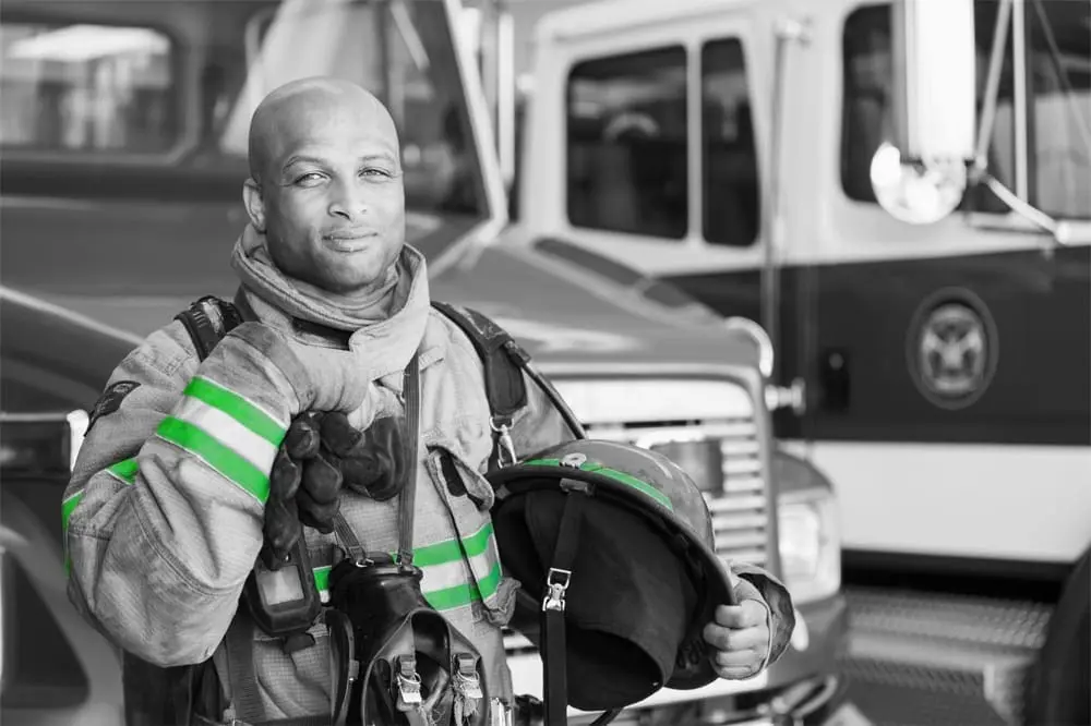 A firefighter in front of a fire truck