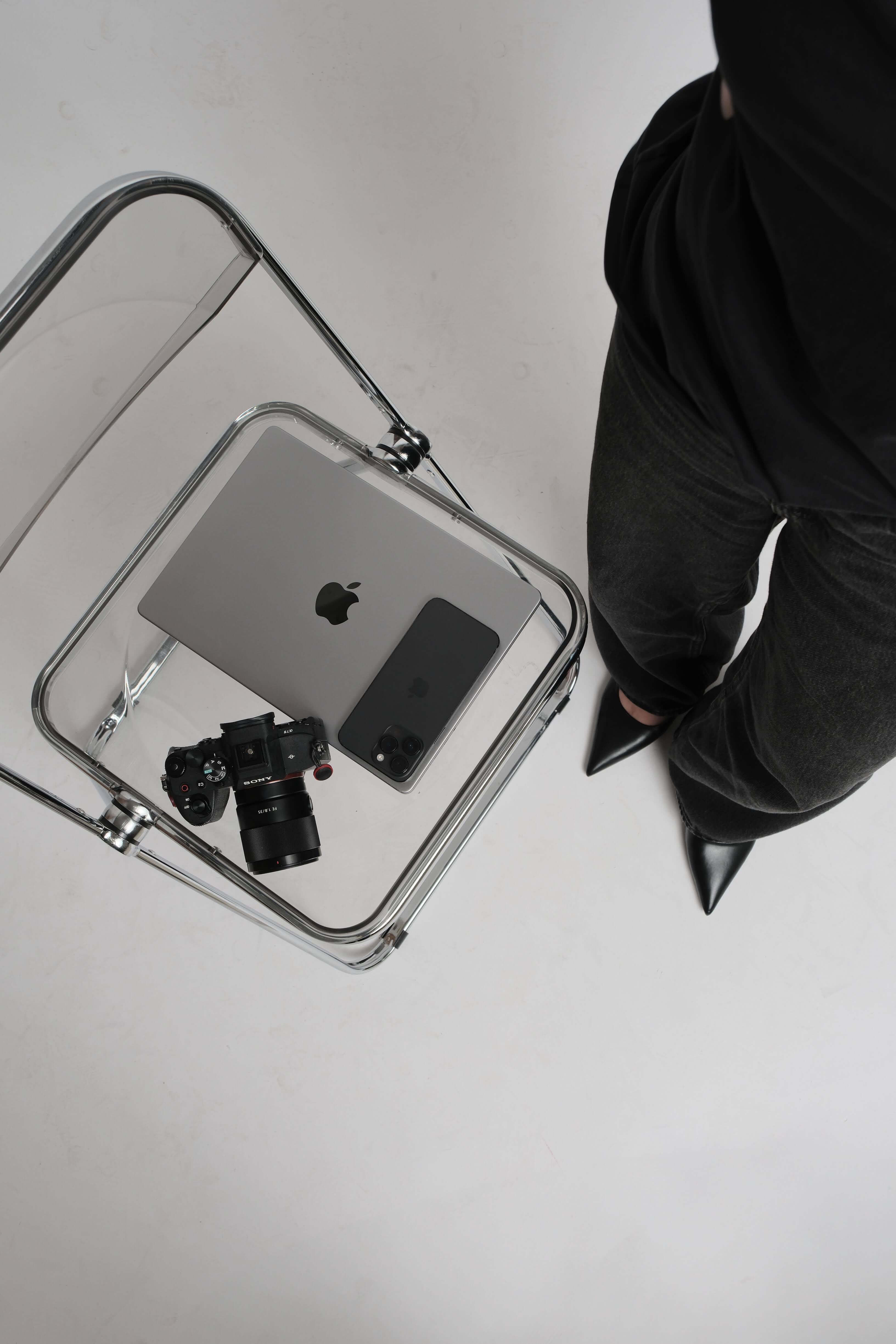 overhead shot of camera, phone, and laptop on chair