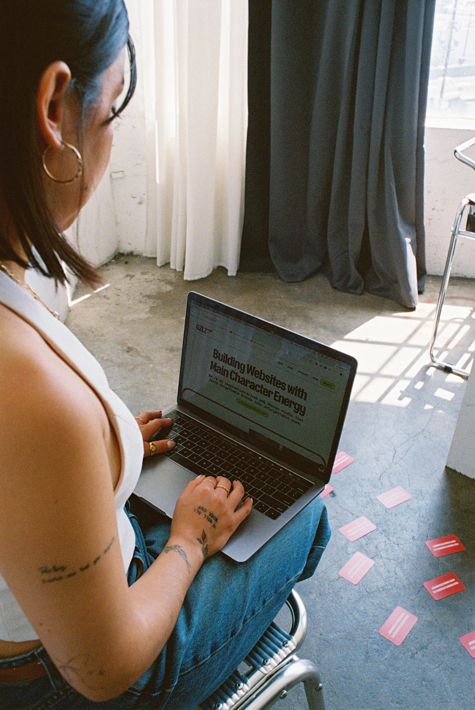 Mayra sitting with her laptop open to GZLZ Design website