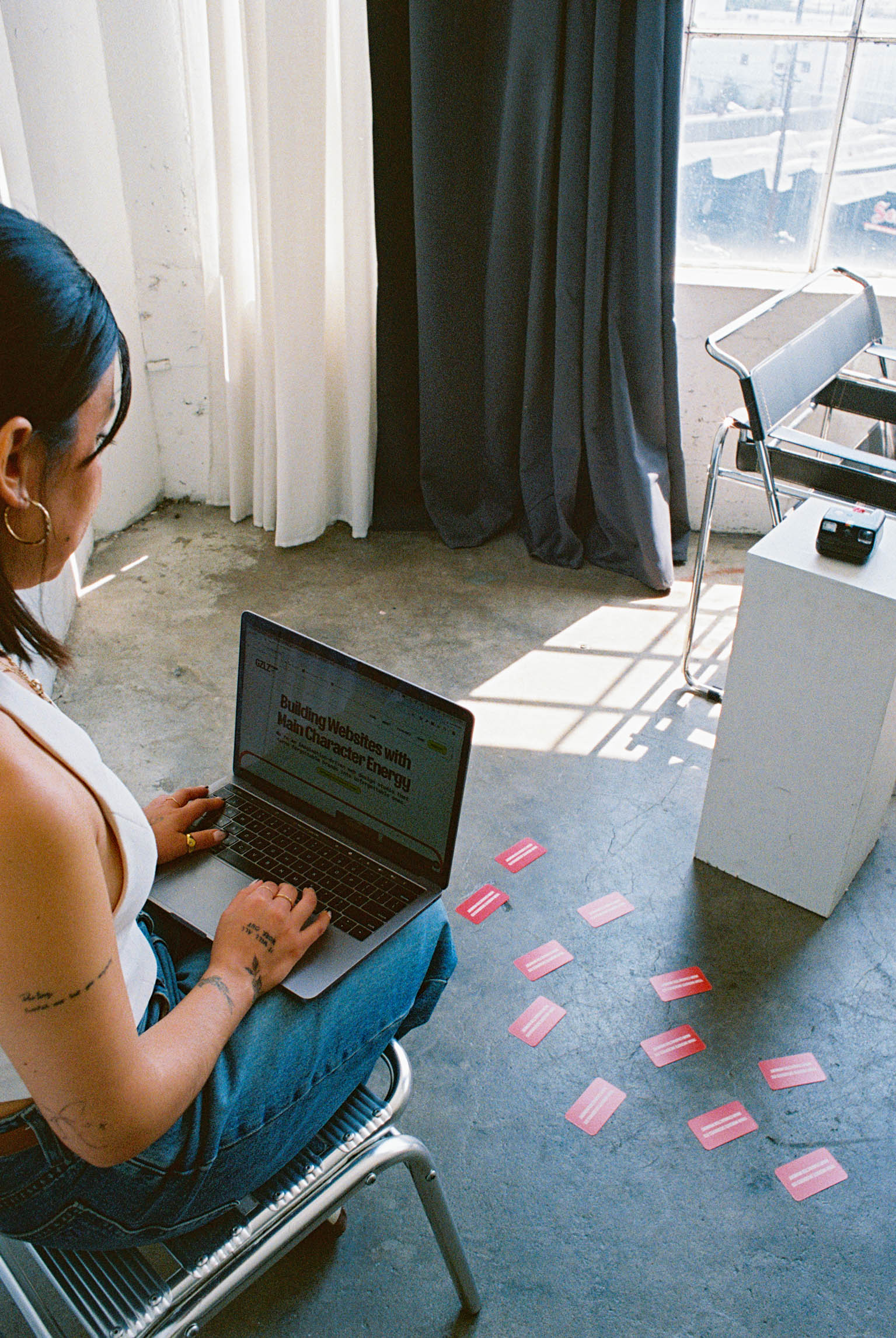 Mayra holding laptop with GZLZ Design website open
