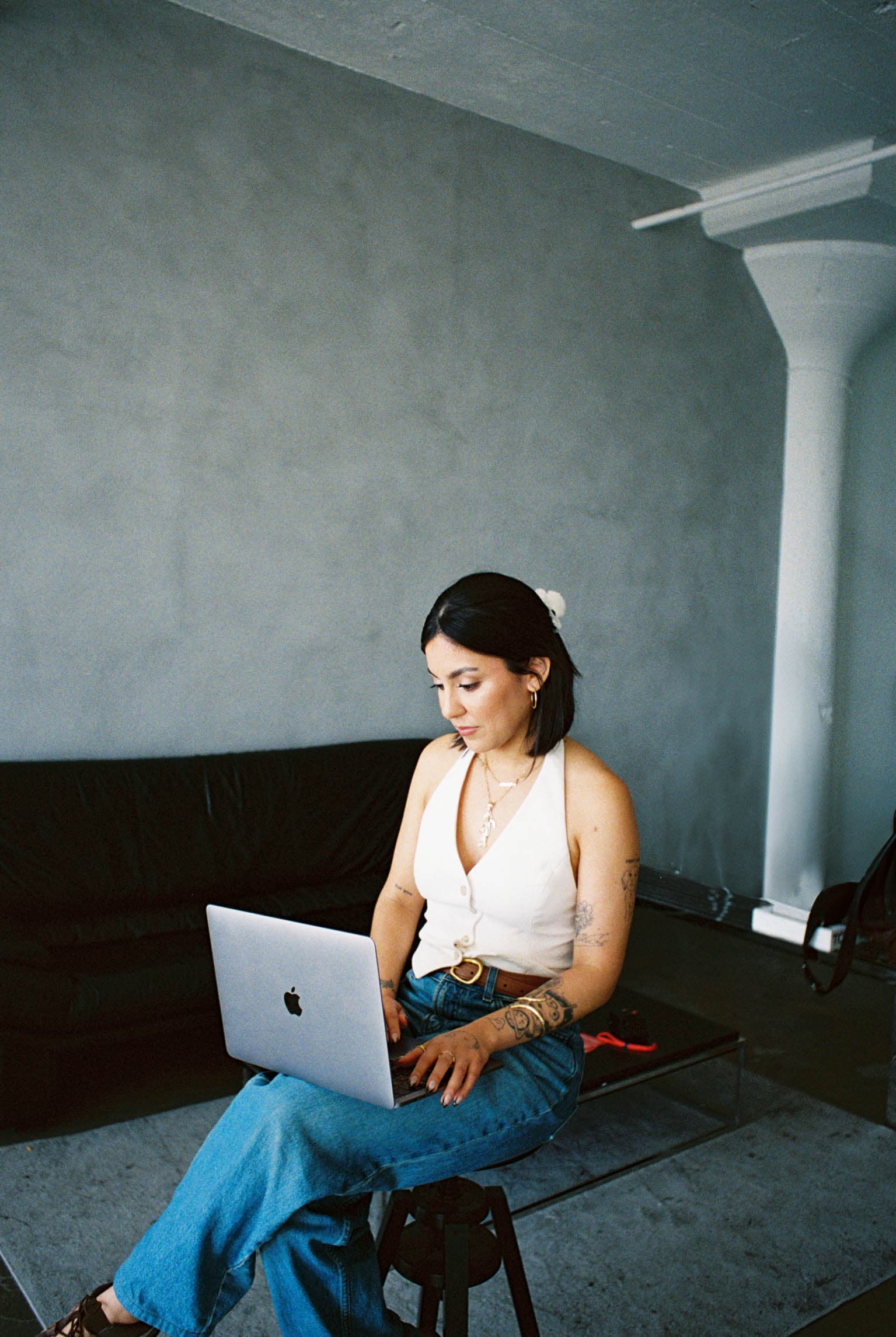 Mayra sitting on chair with laptop