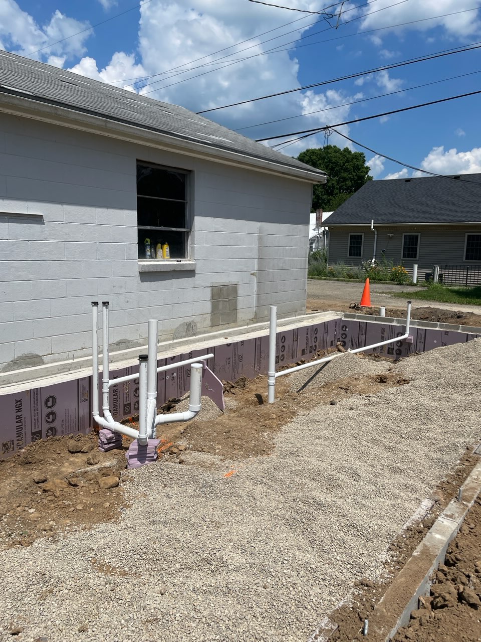 Exposed underground plumbing outside of and next to new home build