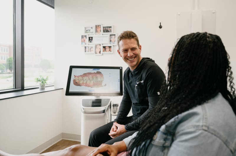 Dentist having consultation conversation with seated patient in office