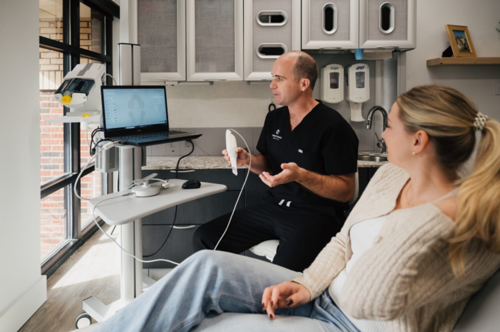 Dentist explaining 3D printing technology and retainer fit to patient
