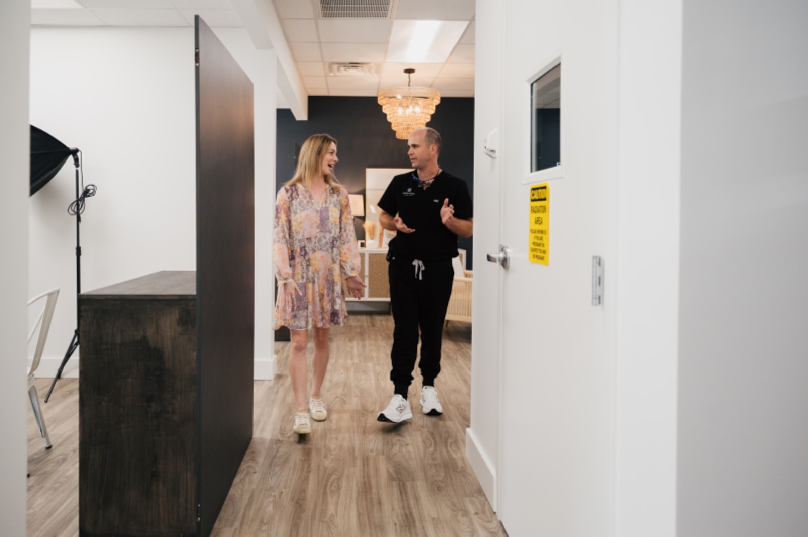 Patient consultation with dental team member in modern office hallway at Everything Dental.