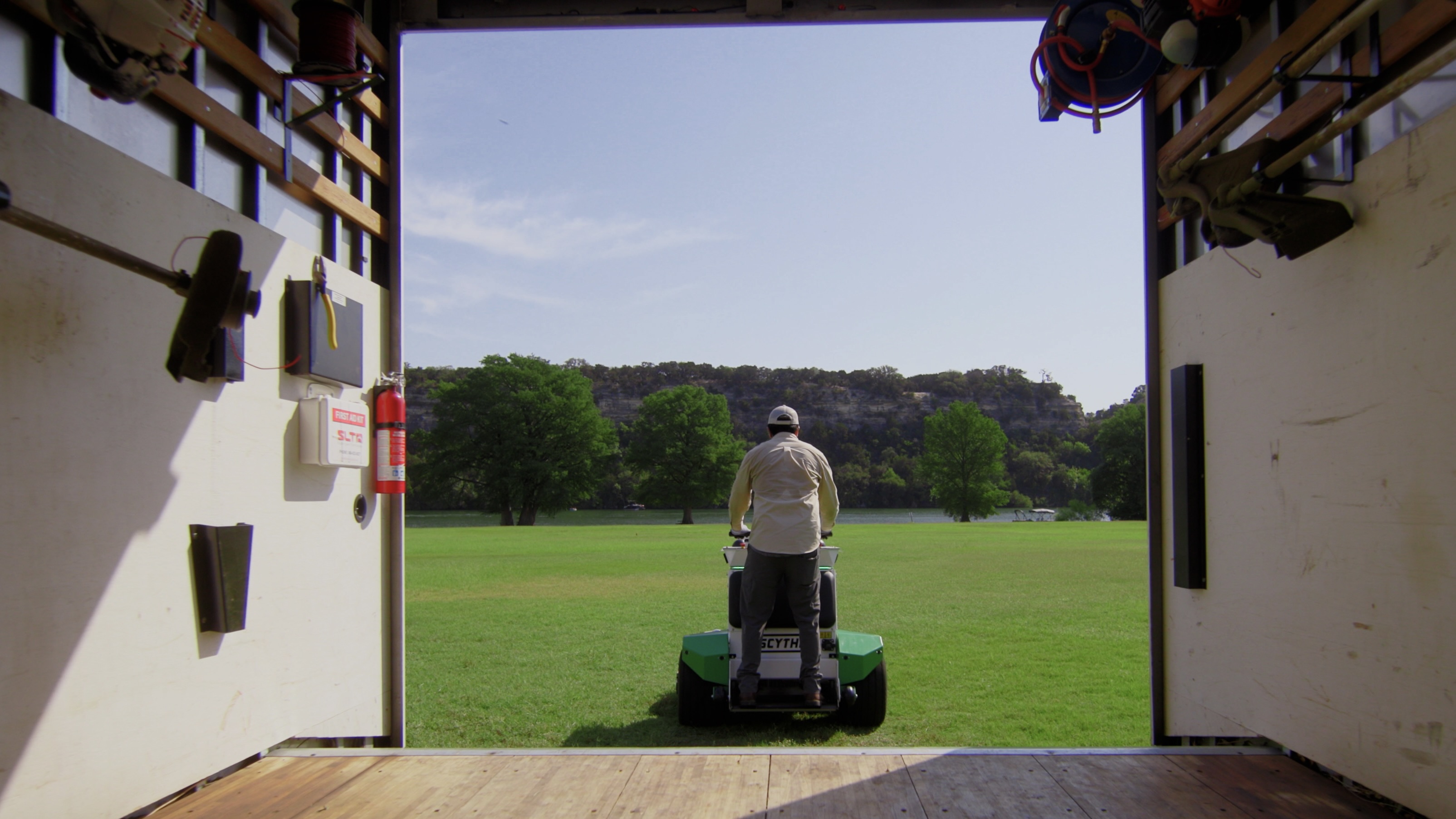 Image of man riding Scythe Mower Robot