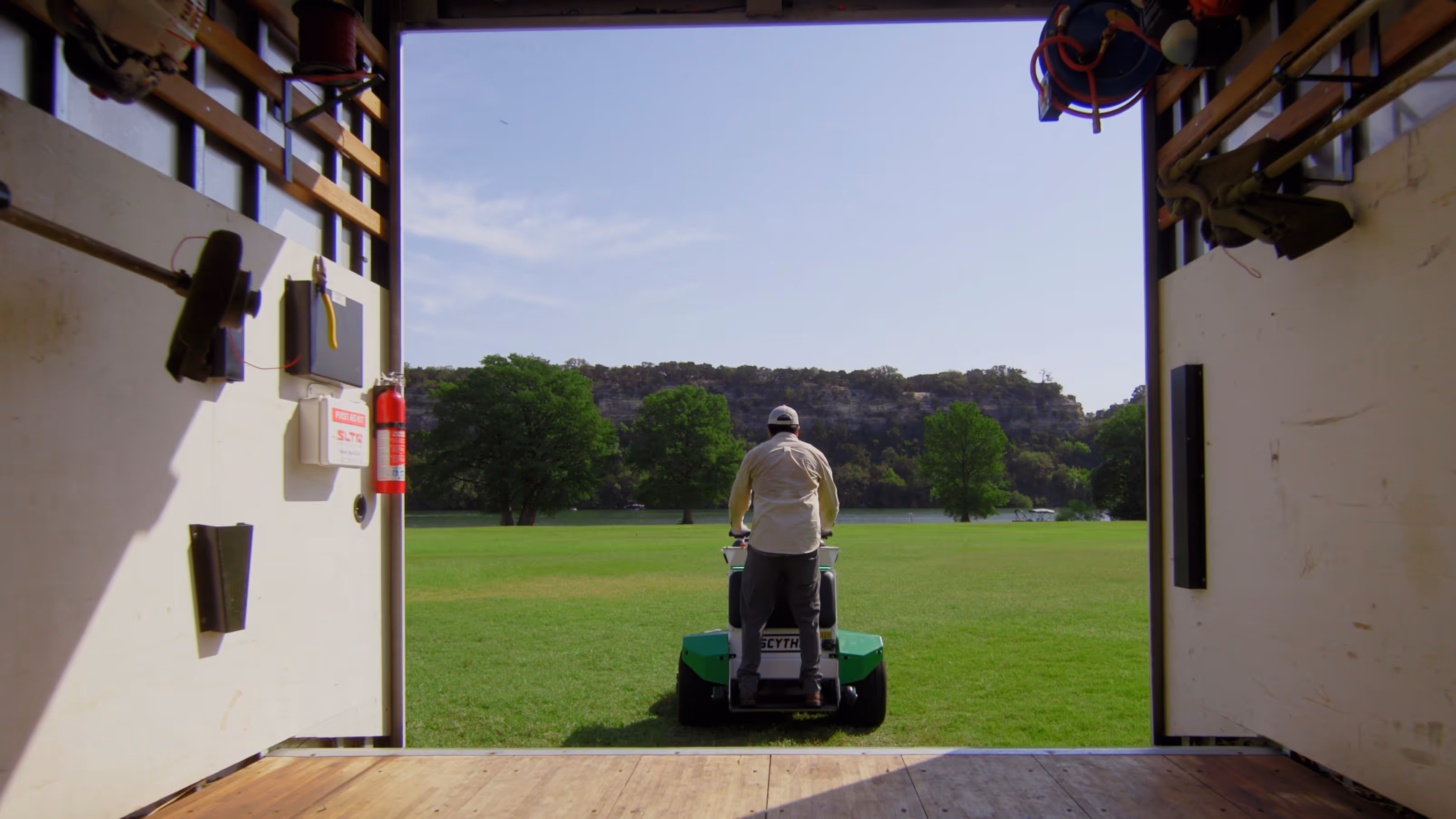 Image of man riding Scythe Mower Robot