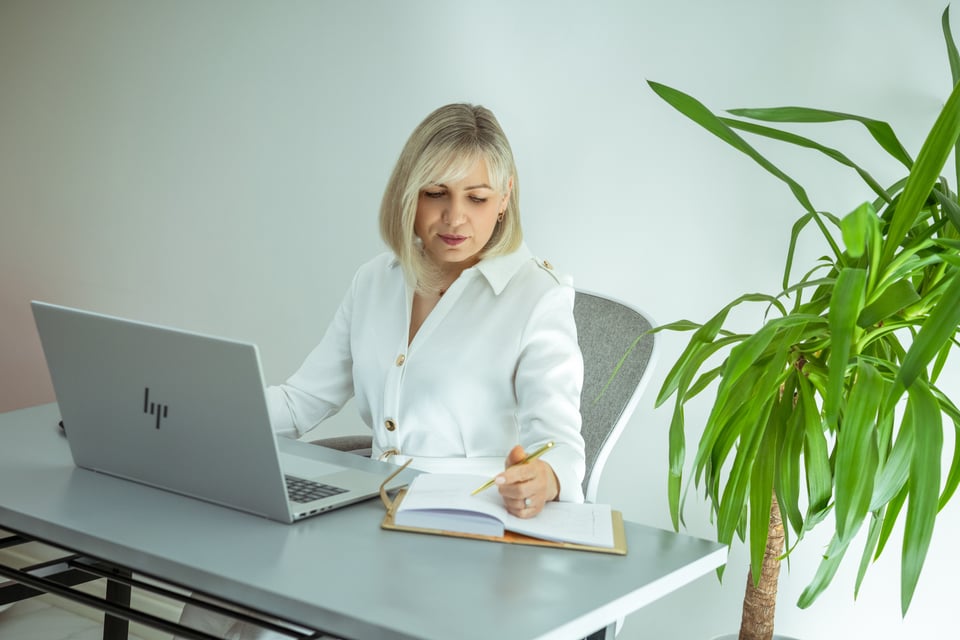 Woman working on laptop at desk with notebook – Createbygyte founder