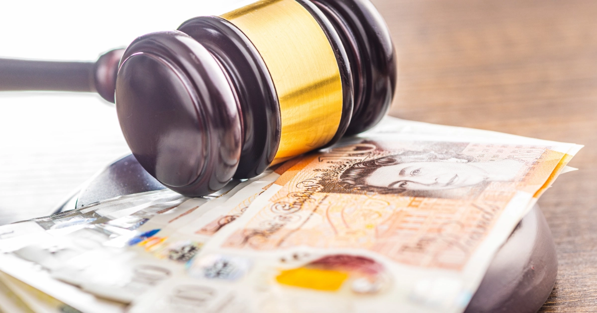 A gavel on top of a stack of £10 notes