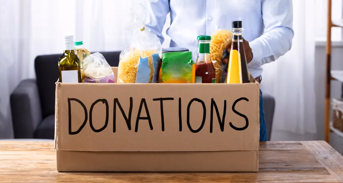 A cardboard box marked "Donations" full of food items