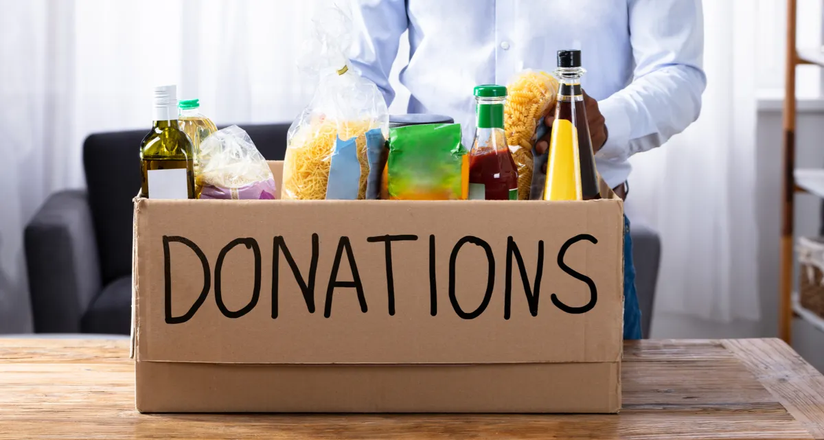 A cardboard box marked "Donations" full of food items