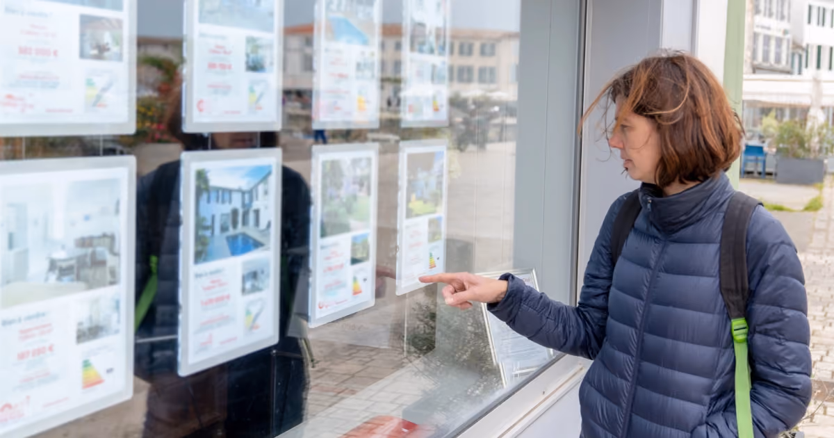 A person looking at property advertisements in a letting agency window