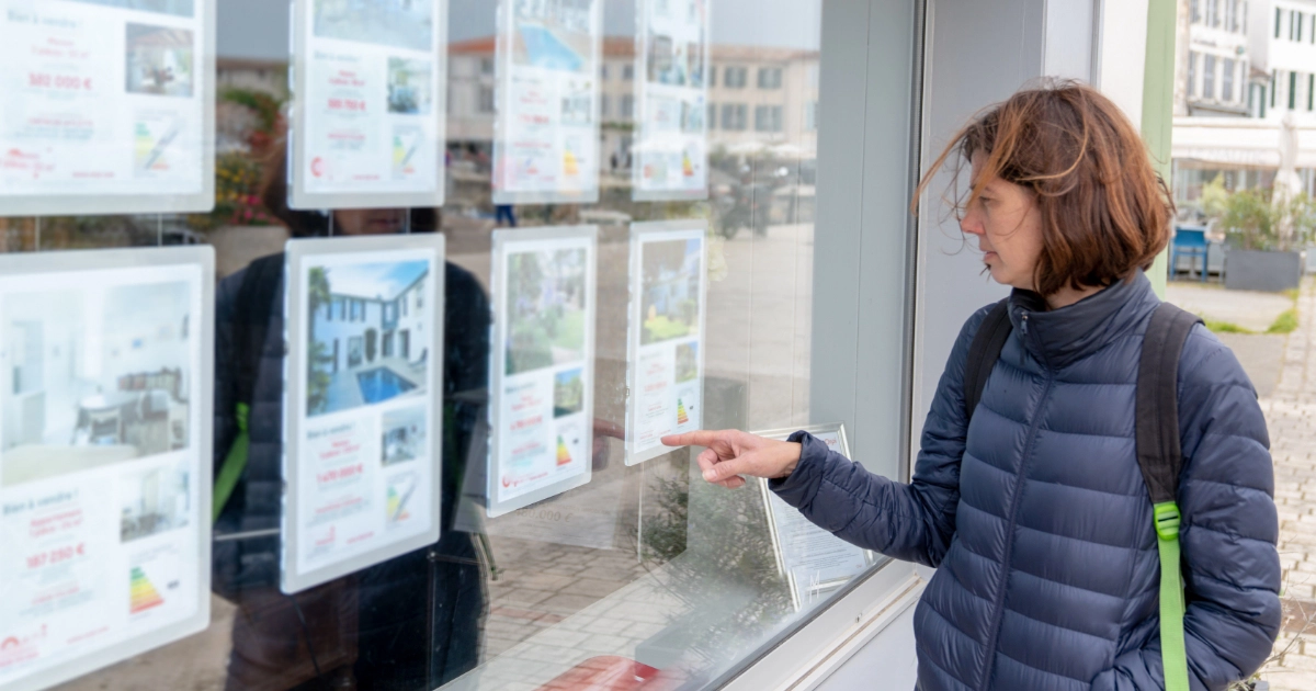 A person looking at property advertisements in a letting agency window
