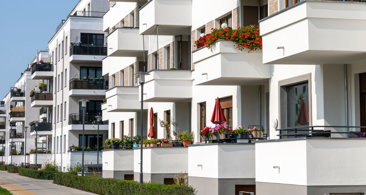 The exterior of a white coloured apartment building with balconies