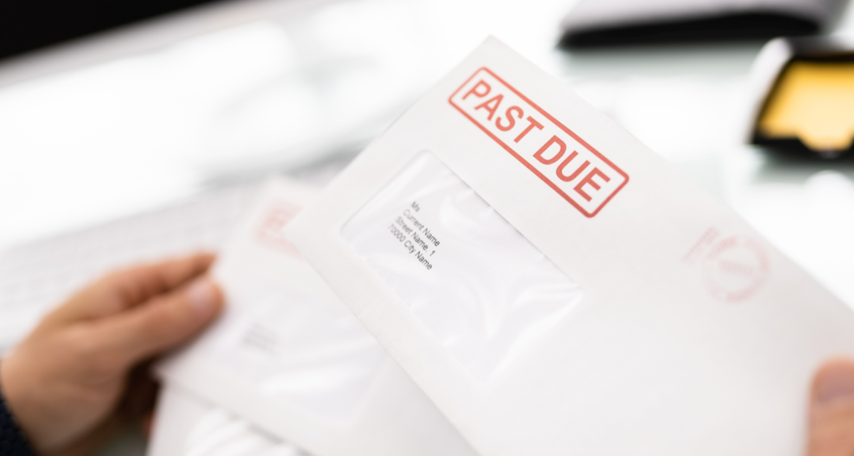 Hands holding an envelope with a red Past Due stamp on it