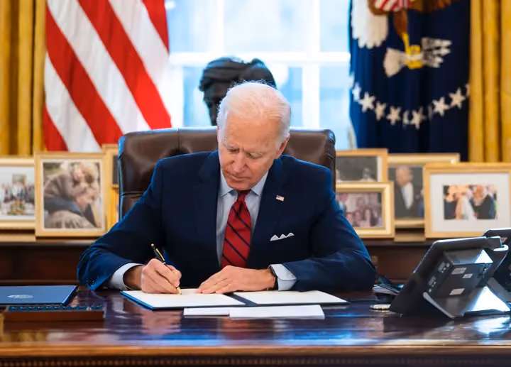 President Joe Biden signs executive actions in the Oval Office of the White House