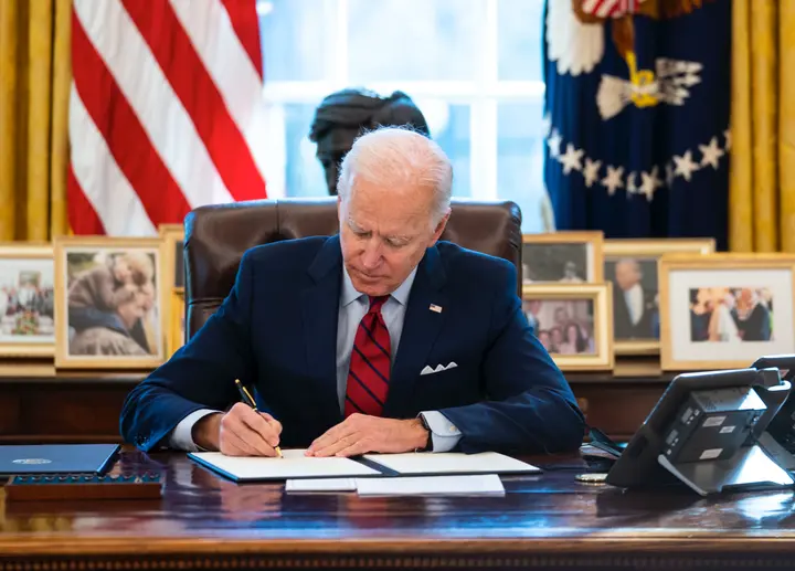 President Joe Biden signs executive actions in the Oval Office of the White House