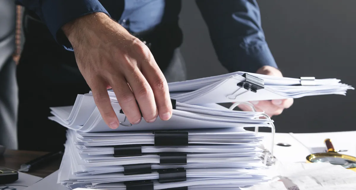 A person going through a stack of papers
