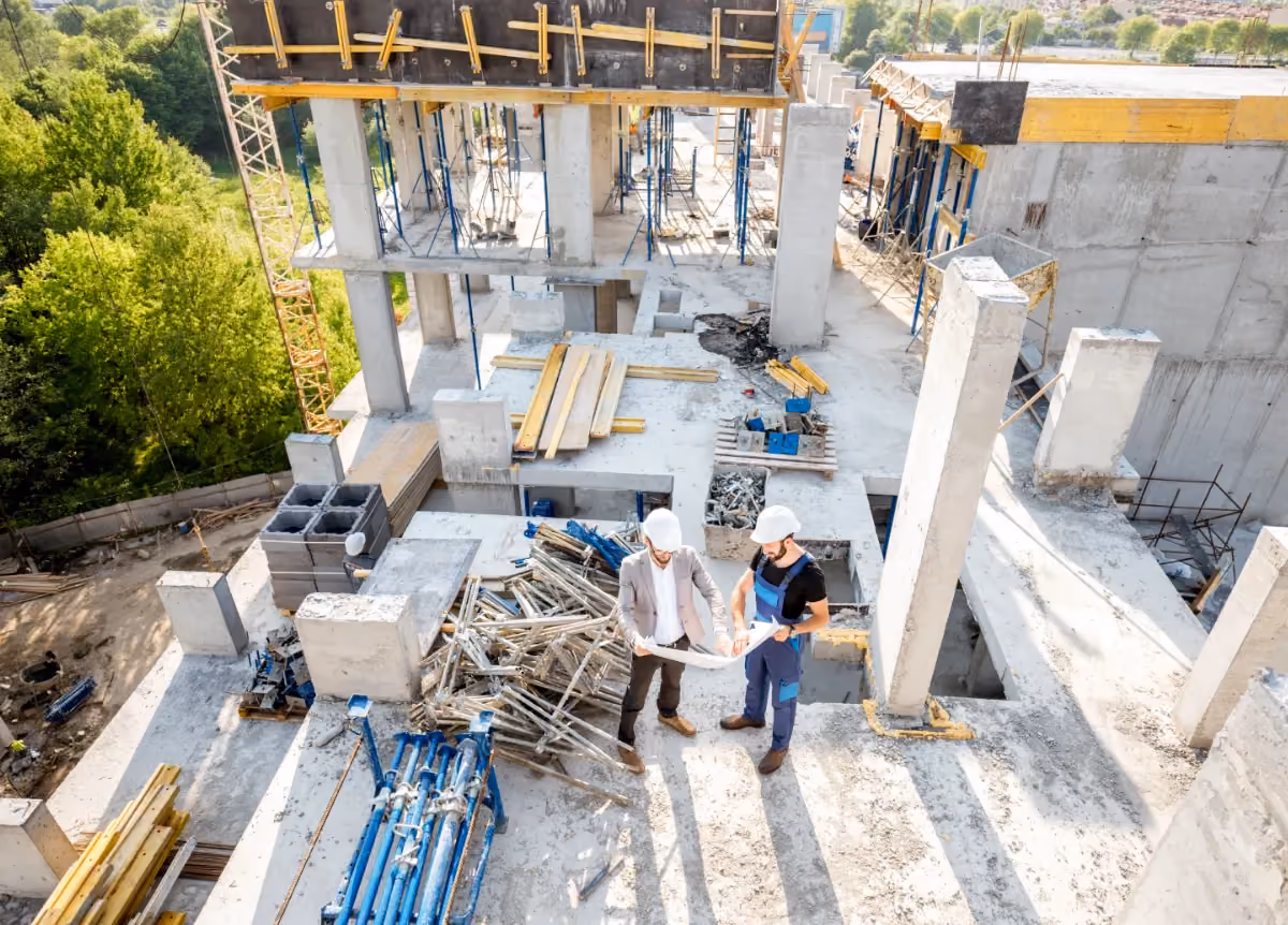 Construction workers looking over blueprints on construction site