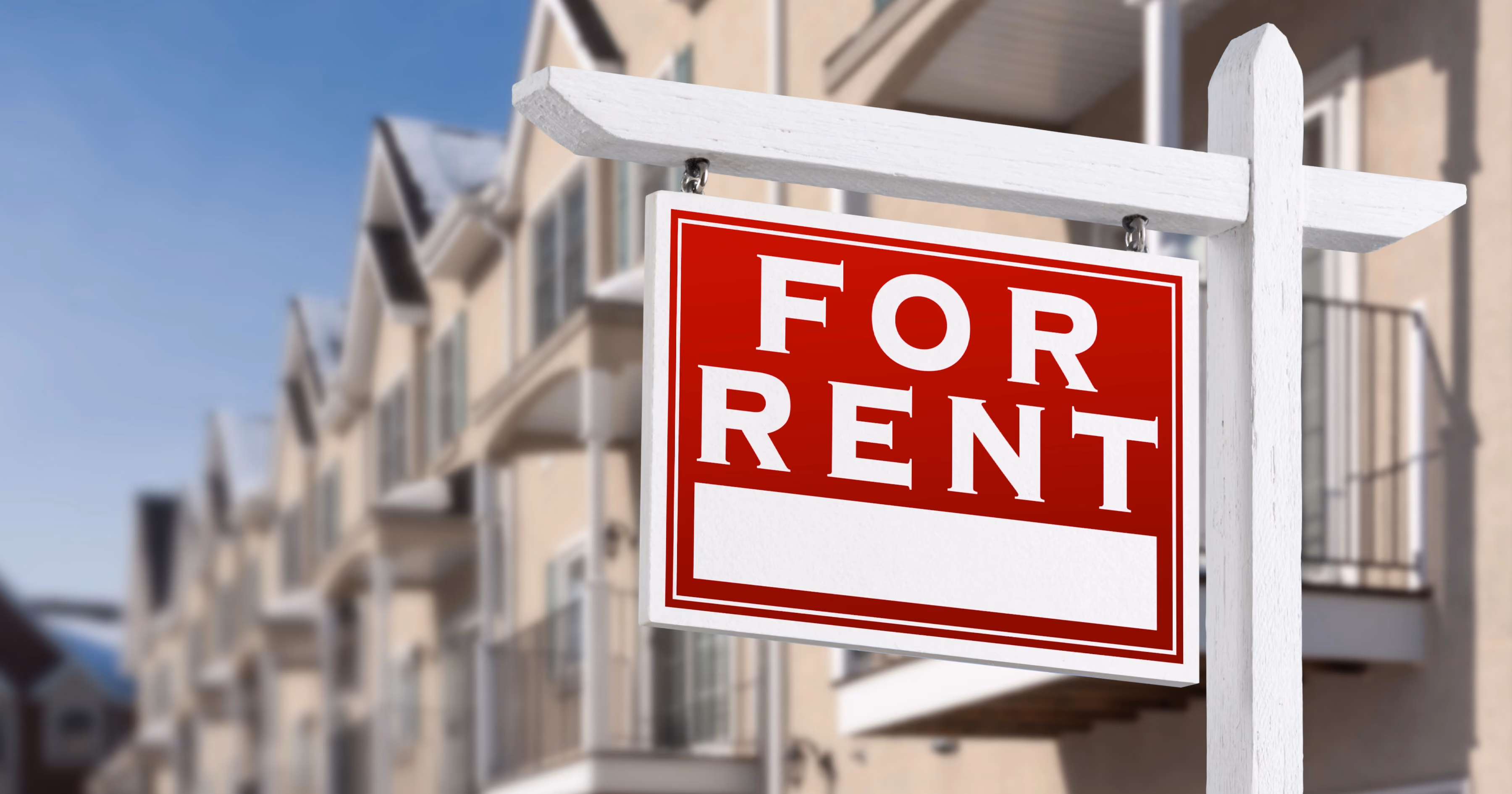 A for sales sign in front of a row of properties