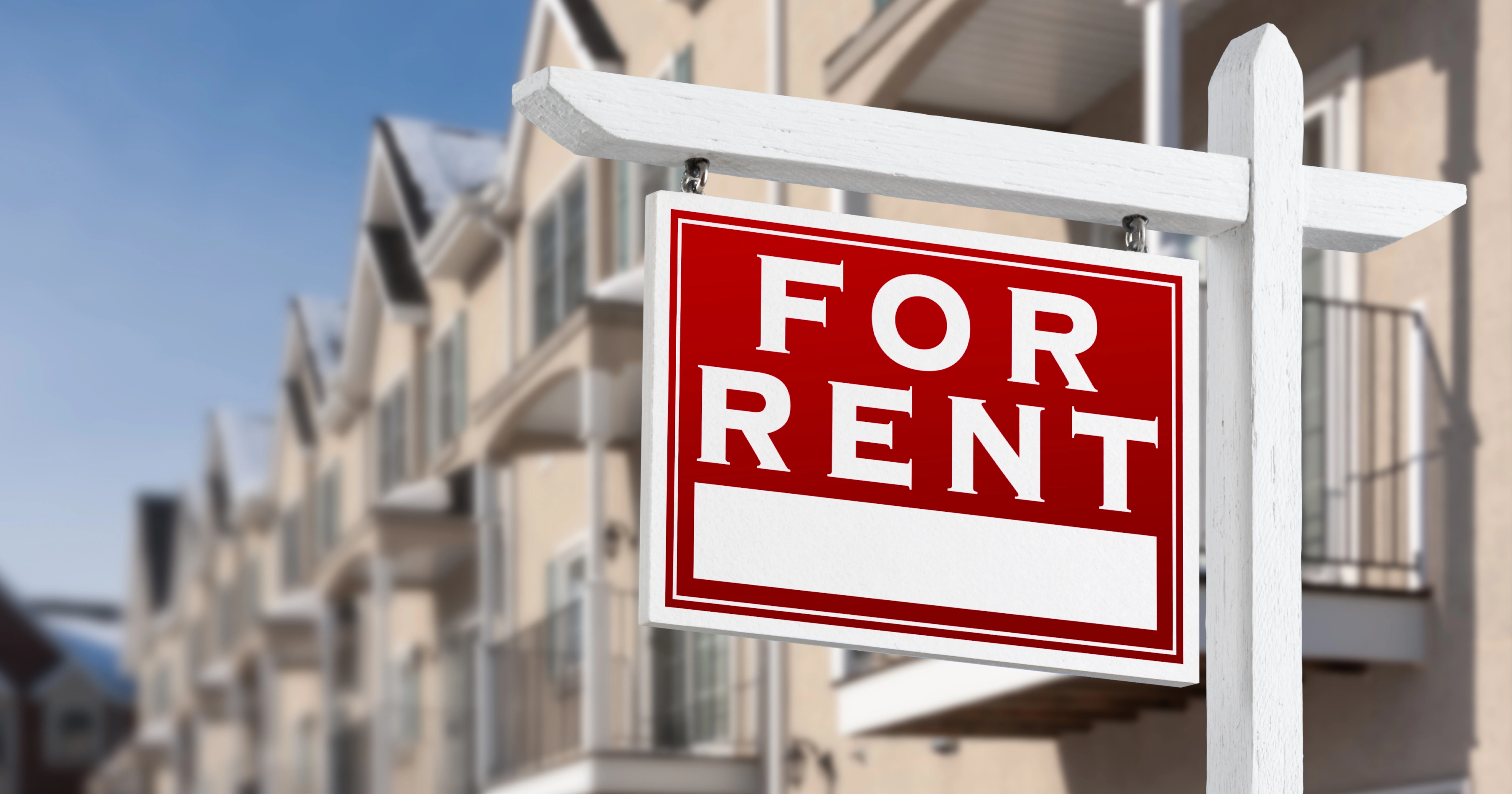 A for sales sign in front of a row of properties