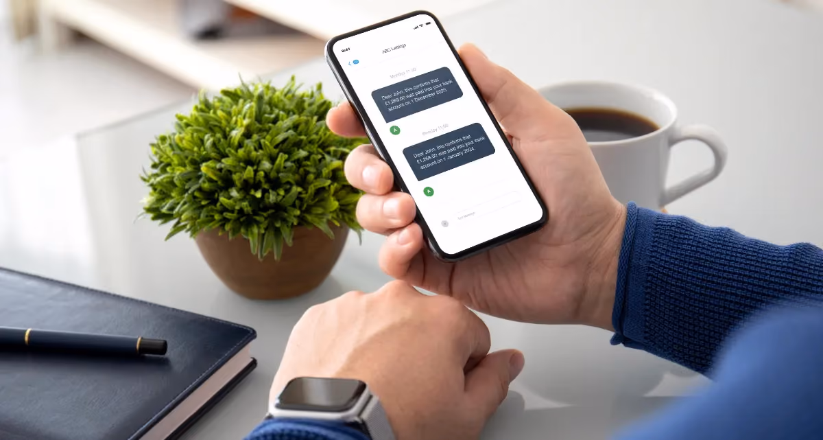 A person holding a phone with a payment notification message displayed on the screen