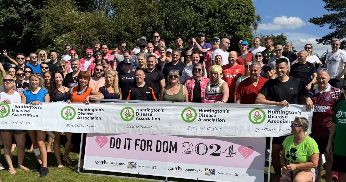 A group of participants holding up a Do It For Dom 2024 banner