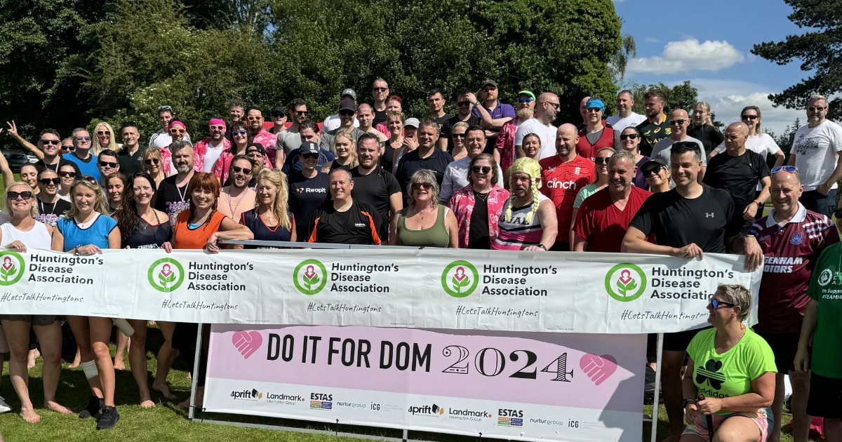 A group of participants holding up a Do It For Dom 2024 banner