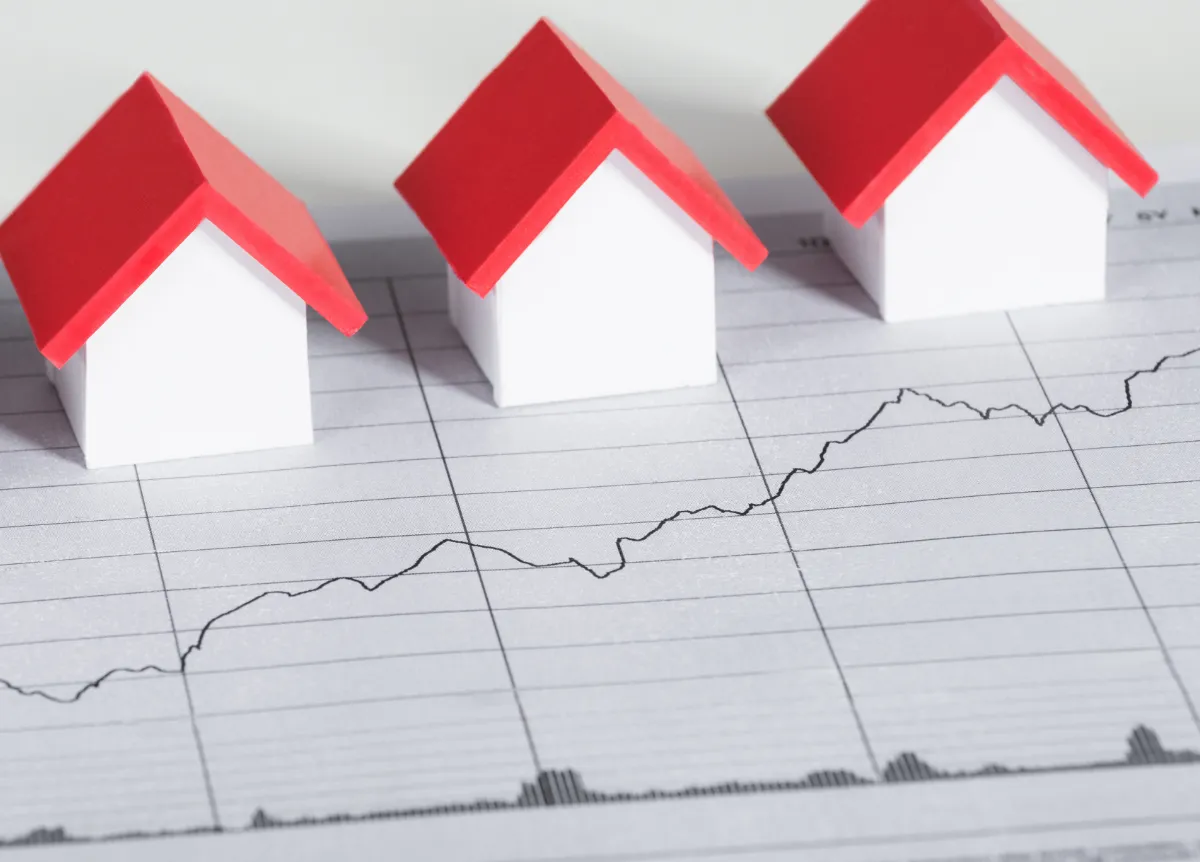 High angle view of house models on top of financial chart