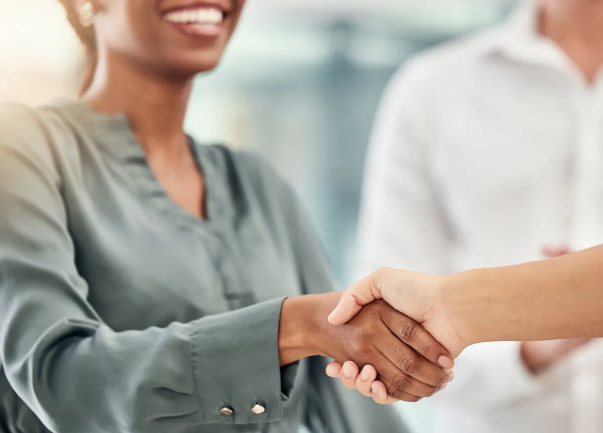 Businesspeople shaking hands and smiling