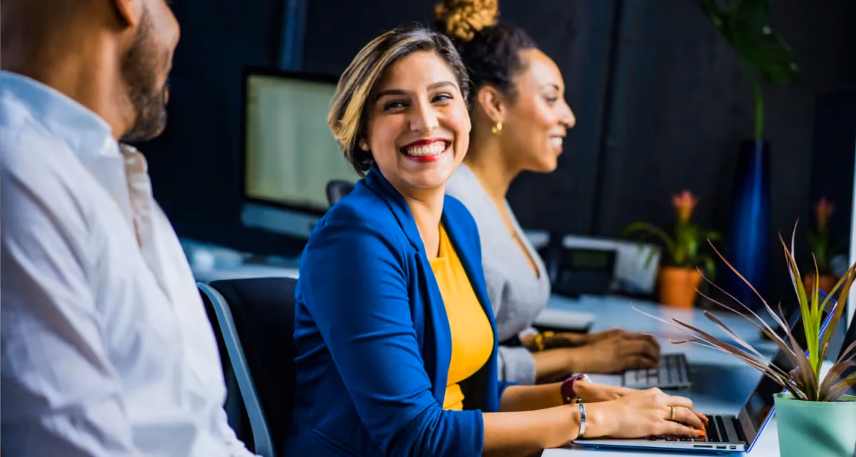 3 cheerful colleagues working together at a desk
