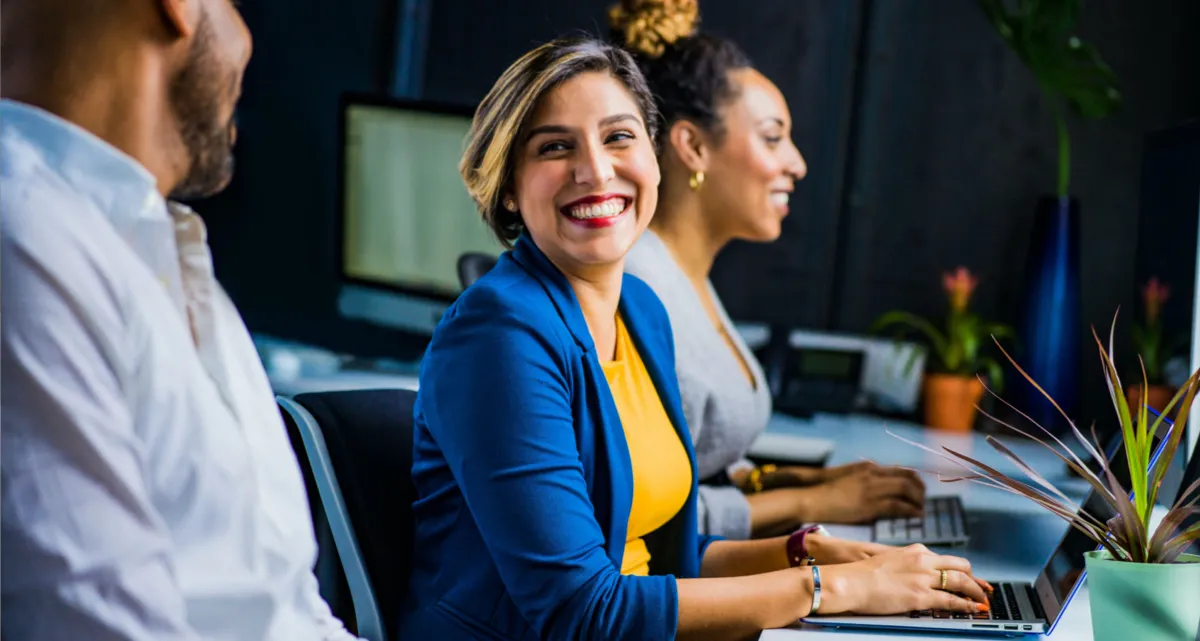 3 cheerful colleagues working together at a desk