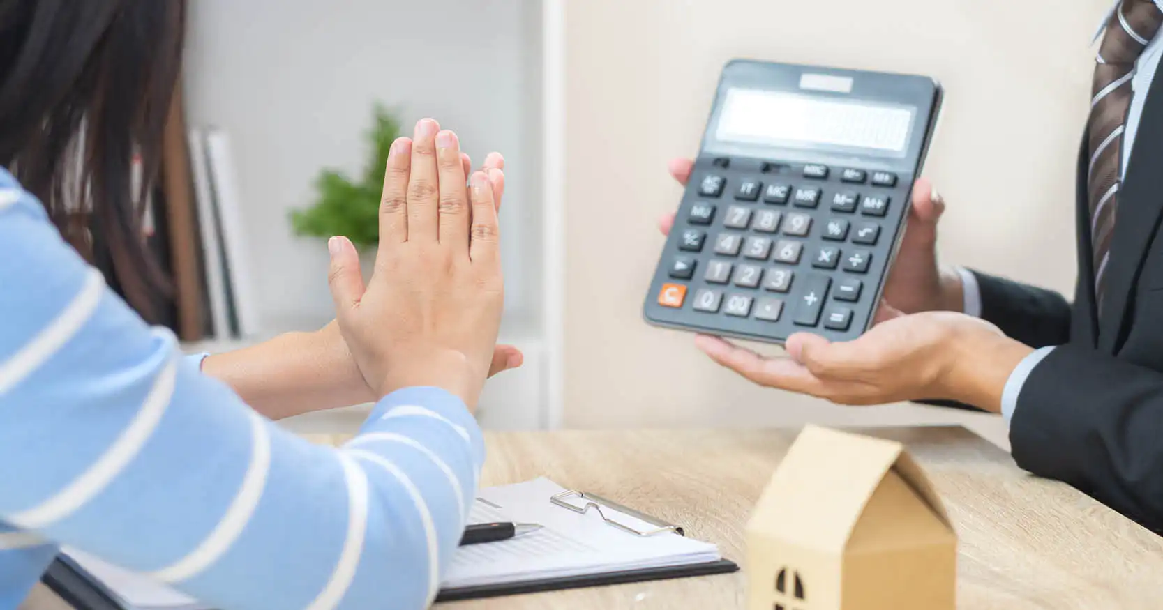 A person holding up a calculator