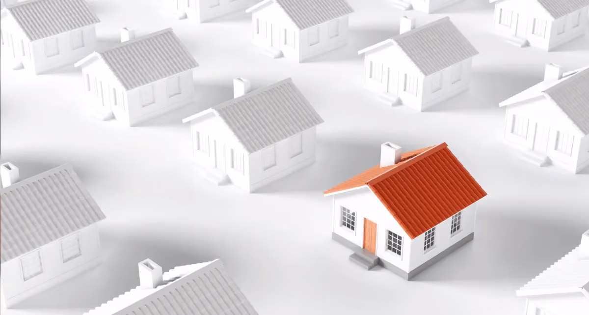 A red and white model house surrounded by greyscale model houses