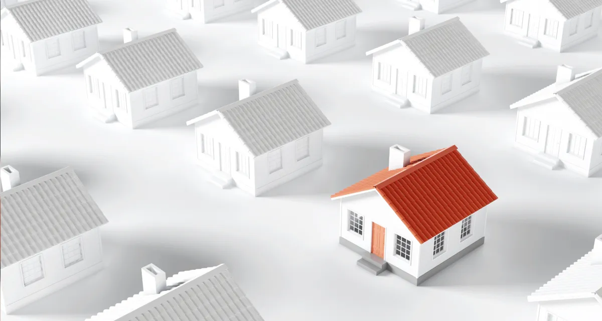 A red and white model house surrounded by greyscale model houses