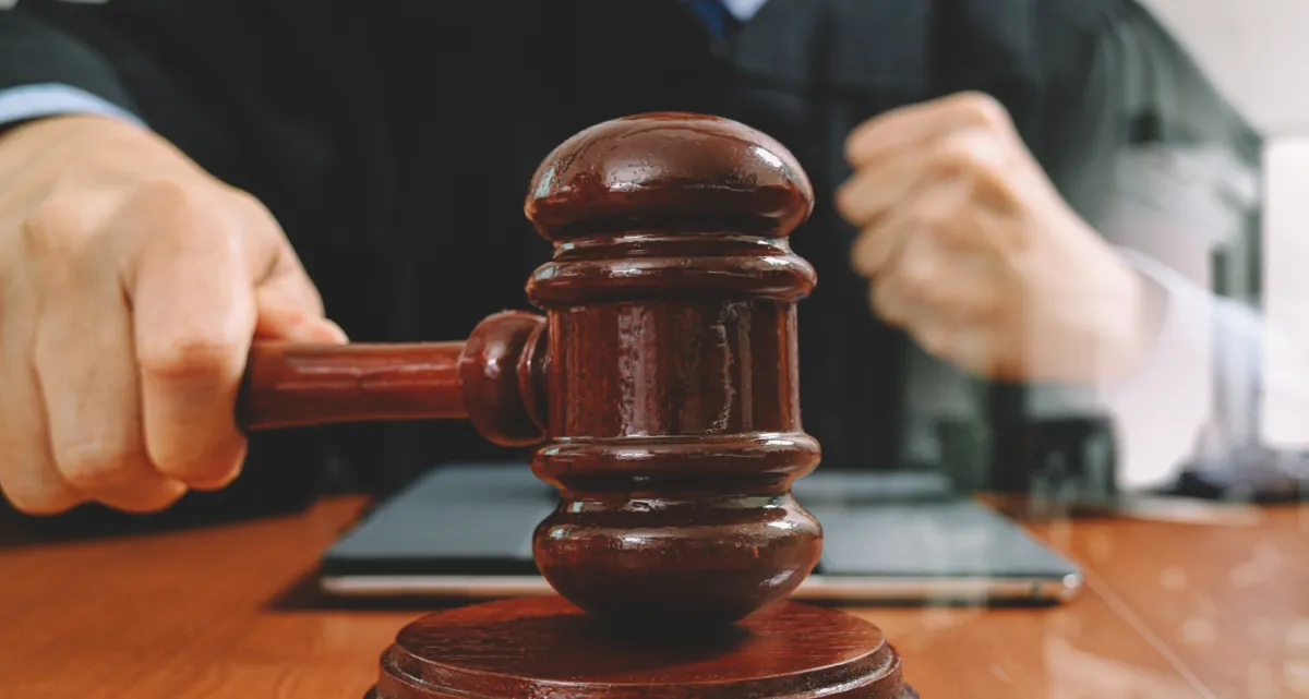 A closeup of a judge's hand striking a gavel