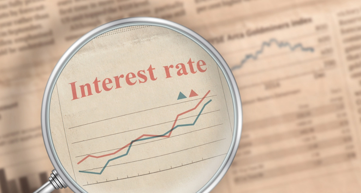 A magnifying glass magnifying "Interest rate" on a newspaper