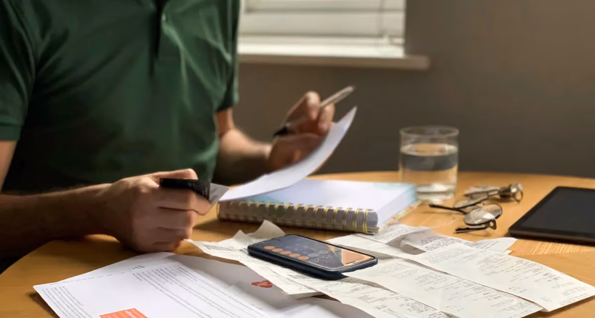 A person looking at a table full of bills