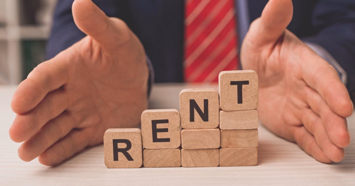 Four wooden letter blocks stepping up, reading "RENT"