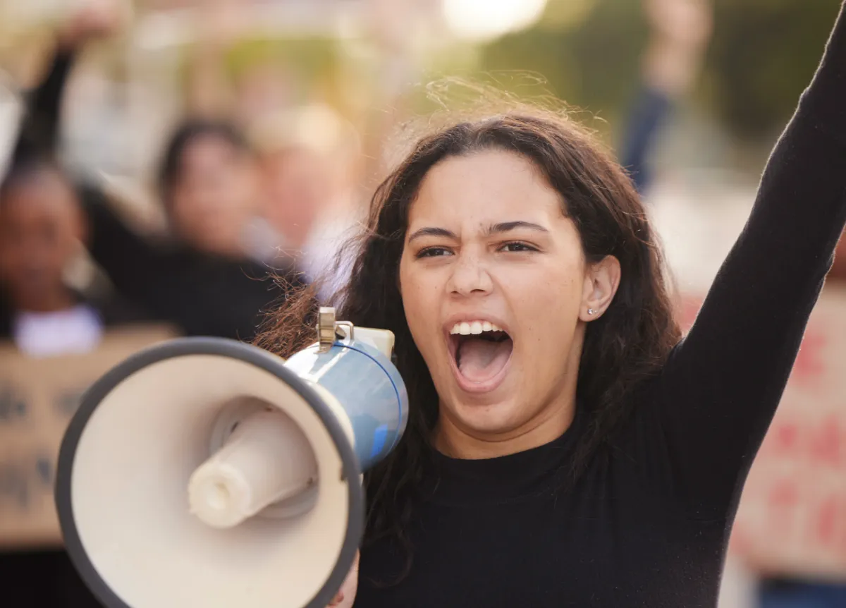 Woman leading protest yells in megaphone