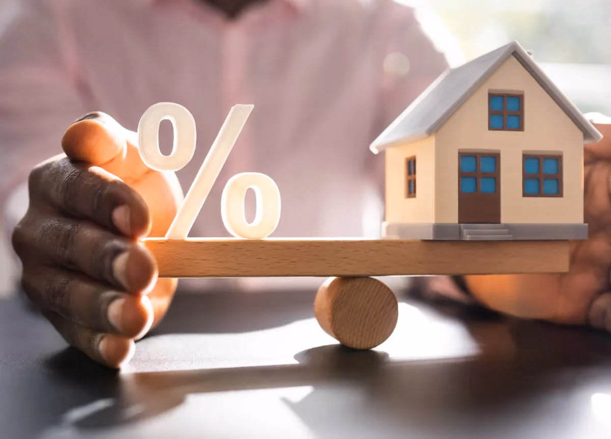 House and percentage symbol balancing on scale