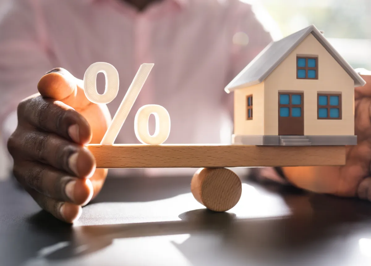 House and percentage symbol balancing on scale
