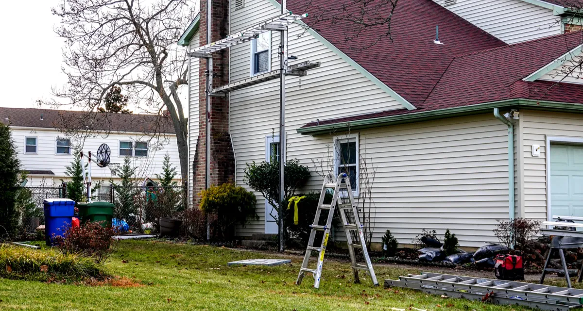 The side of a house with scaffolding and ladders up