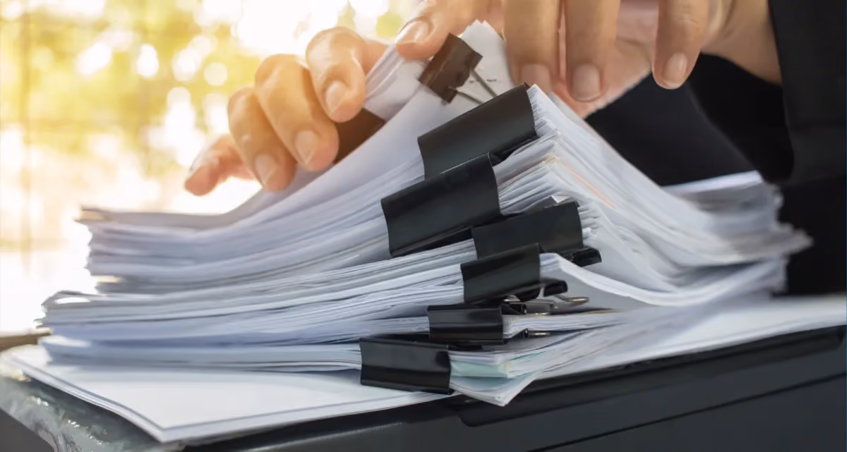 A stack of documents in binder clips