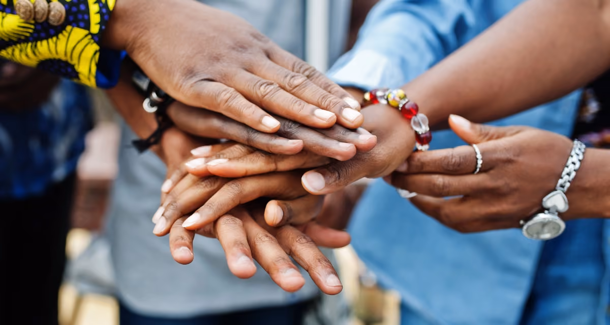 A group of people stacking their hands on top of each other