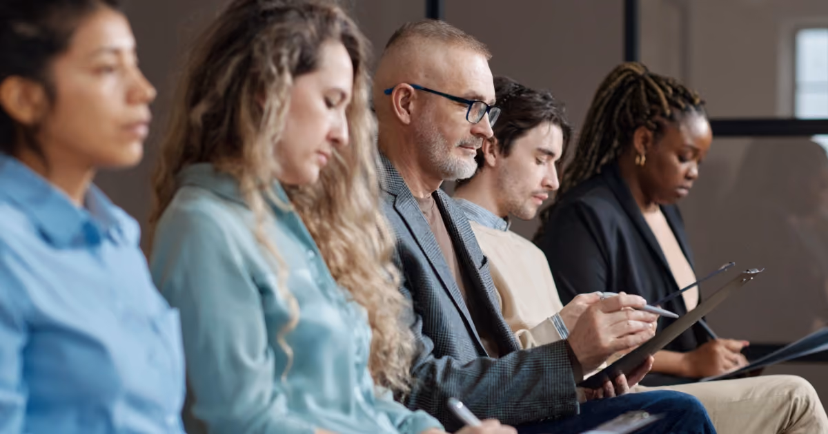 A group of seated people taking notes in a lecture