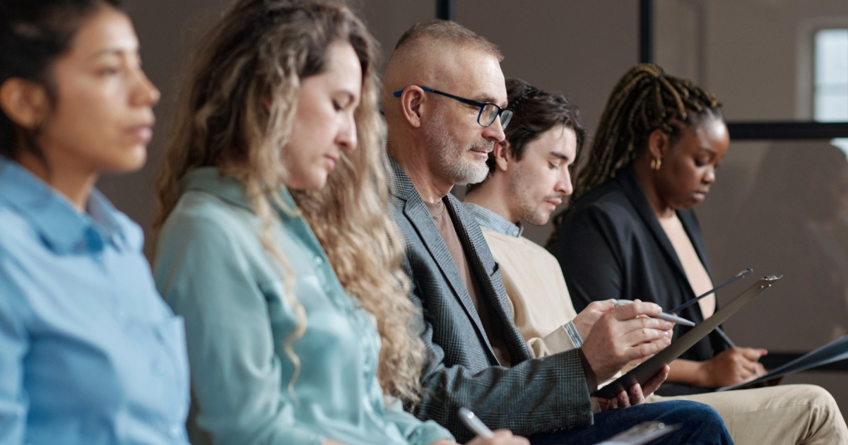 A group of seated people taking notes in a lecture